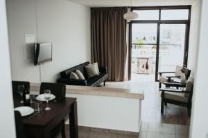 uma sala de estar com um sofá e uma mesa em Ovis Hotel Apartments em Agia Napa