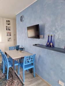 a dining room with a table and blue chairs at B&B DIANA in Pordenone