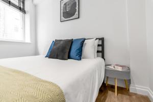 a bedroom with a bed with blue and white pillows at Nadler Studios in Norwich