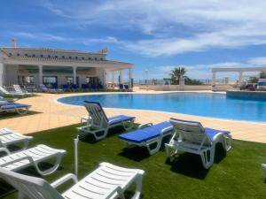 a pool with chaise lounge chairs and a resort at 12 A Clube Golfemar in Carvoeiro
