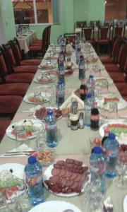 una mesa larga con platos de comida y botellas de agua en Family Hotel Panorama, en Sarnitsa