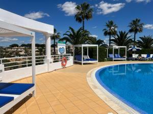a pool on the balcony of a resort with palm trees at 12 A Clube Golfemar in Carvoeiro