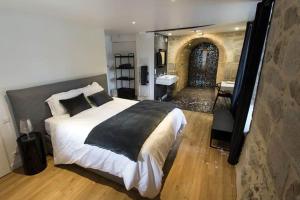 a bedroom with a large bed and a bathroom at Chateau De Val in Lanobre