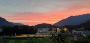 a sunset over a city with mountains in the background at Ferienwohnung Haus Stadler in Bad Ischl