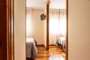 a mirror in a room with two beds and a window at Hostal Restaurante Ventasierra in Valdoré +39 photos