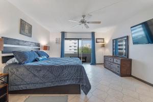 a bedroom with a bed and a flat screen tv at Beautiful Condo on the Beach in Freeport, Bahamas! in Pinders Point