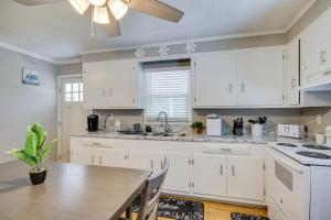 cocina con armarios blancos y mesa de madera en McCormick Vacation Rental 2 Mi to Lake Thurmond! en McCormick