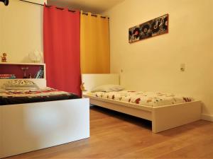 a room with two beds and a curtain at Bel appartement au coeur de la cité médiévale in Sommières