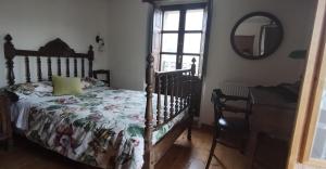 a bedroom with a bed and a mirror and a chair at HOTEL RURAL LA ENGAÑA in Pedrosa