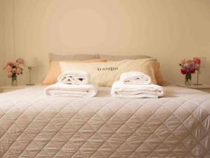 1 dormitorio con 1 cama con toallas en Comfort Cochera Cercano Centro Wifi 300Mb-seg en San Carlos de Bariloche