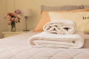 una pila de toallas sentadas encima de una cama en Comfort Cochera Cercano Centro Wifi 300Mb-seg en San Carlos de Bariloche