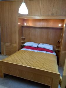 a bedroom with a bed with a wooden headboard at Casa Mirtillo in Lizzano in Belvedere