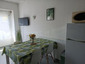 a dining room with a table and a refrigerator at Gite Duguesclin in La Flocellière