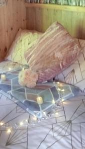 Una almohada en una cama con luces. en 'Morris' the shepherd's hut with woodland hot tub, en Carmarthen