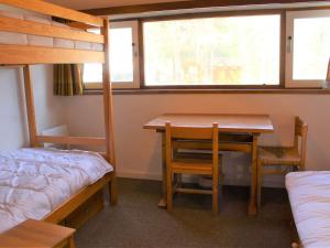 Zimmer mit einem Tisch, einem Bett und Etagenbetten in der Unterkunft Appartement Vars, 2 pièces, 6 personnes - FR-1-330B-163 in Vars