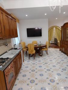 a kitchen with a table and a tv on the wall at Villa Cinzia in Sant'Agnello