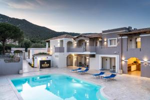 a villa with a swimming pool in front of a house at Istedda Boutique Hotel in Solanas