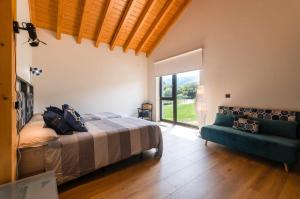 a bedroom with a bed and a couch and a window at Villa Vacacional La Raizona in Pancar +38 photos