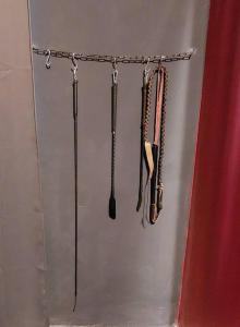 a group of utensils hanging on a wall at Budapest BDSM Studio in Budapest