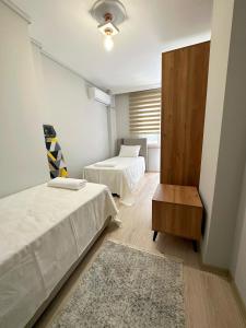 特拉布宗的住宿－İMA APART，酒店客房设有两张床和一张桌子。