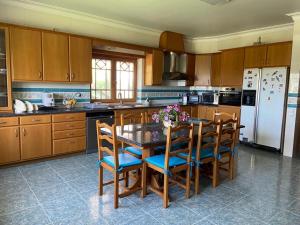 La cuisine est équipée d'une table, de chaises et d'un réfrigérateur. dans l'établissement Casa Grande, 