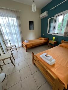 a room with two beds and a couch and a chair at Lydia’s house in Argostoli