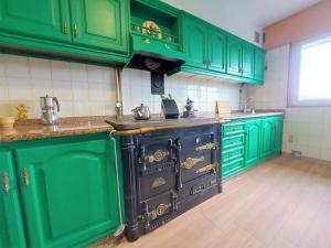 a kitchen with green cabinets and an oven in it at Casa Dabuela Costa da Morte in Muxia