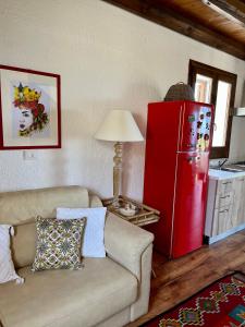 un soggiorno con divano e frigorifero rosso di Casale Toia a Scopello