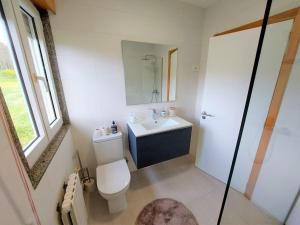 a bathroom with a toilet and a sink and a mirror at Casa Dabuela INCostadaMorte in Muxia +17 photos