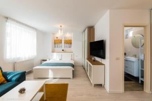 Una pequeña habitación con una cama y un televisor. en Red Fountain Studio, en Brasov