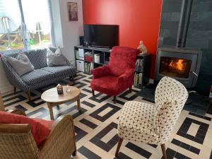 sala de estar con sillas y chimenea en Chez Viviane, en Fontaine-Étoupefour