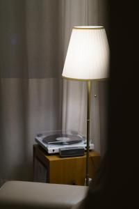 a lamp sitting on a table next to a bed at windmill house in Daegu