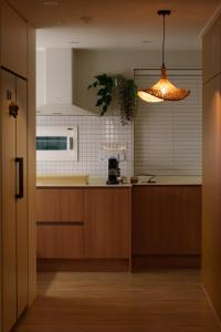 a kitchen with wooden cabinets and a light fixture at windmill house in Daegu