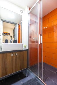 ein orangefarbenes Badezimmer mit einem Waschbecken und einer Dusche in der Unterkunft Wesselenyi 40 Apartment in Budapest
