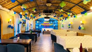 ein Restaurant mit Tischen, Stühlen und Ballons an der Decke in der Unterkunft Hotel The Mewar in Panwāri