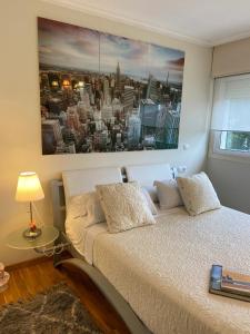 a bedroom with a bed with a painting on the wall at Casa Javson in A Coruña