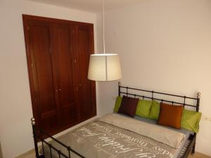 1 dormitorio con 1 cama con almohadas de color verde y naranja en Apartamento La vida en Málaga