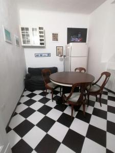 una cucina con tavolo, sedie e frigorifero di Gallery House a Fermo