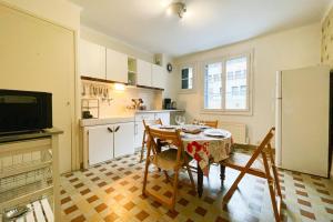 eine Küche mit einem Tisch und Stühlen sowie einem Kühlschrank in der Unterkunft The Harmony of Eras #FL in Grenoble