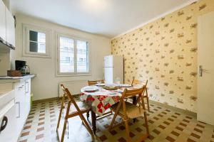 eine Küche mit einem Tisch mit Stühlen und einem Kühlschrank in der Unterkunft The Harmony of Eras #FL in Grenoble