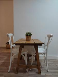 un tavolo in legno con due sedie e una pianta in vaso di VFT Puerta de Córdoba a Baeza