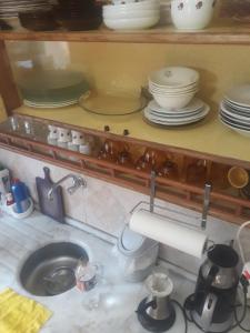 eine Küchenspüle mit Tellern und Geschirr auf einem Regal in der Unterkunft Nokta evler 