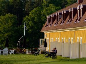 a couple of people sitting in chairs in front of a building at Körunda Golf & Conference Hotel in Ösmo