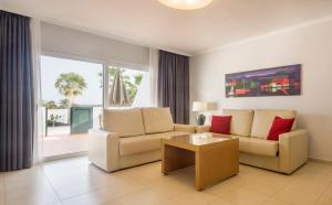 a living room with a couch and a table at ILUNION Costa Sal Lanzarote in Puerto del Carmen
