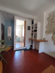 een woonkamer met een tafel en een deur naar een kamer bij Chambre d'hôtes Les Tomettes in Vence