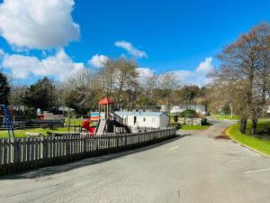 un parque con valla y parque infantil en Roslyn at Lower Hyde Park, Isle of Wight, en Shanklin