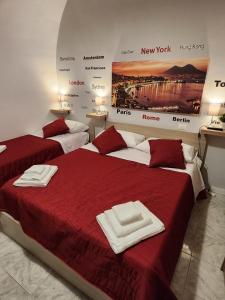 two beds in a room with red sheets and towels at PURGATORIO HOUSE in Naples