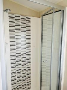 a bathroom with a shower and a glass door at Roslyn at Lower Hyde Park, Isle of Wight in Shanklin