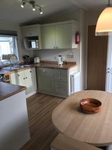 a kitchen with a wooden bowl on a wooden table at Roslyn at Lower Hyde Park, Isle of Wight in Shanklin