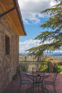patio z krzesłami i stołem z widokiem w obiekcie Agriturismo La Collina Toscana w mieście Pieve a Maiano